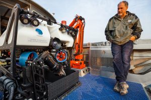 GFOE President and Founder Dave Lovalvo stands next to ROV Yogi on the deck of the R/V Annie. Credit: Daniel R. Rogers, GFOE